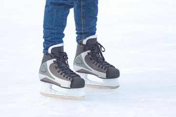 Legs of a man skating on an ice rink. Hobbies and sports. Vacations and winter activities.