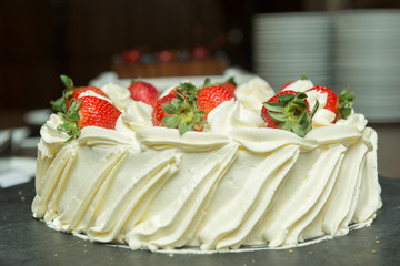 Side view of creamy white chocolate cake with strawberry slices. Sweet dessert about ardoia. Sweet concept for celebrations. Focus selective.