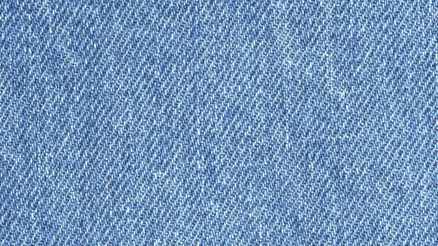 Jeans fabric plain surface background. Denim textile texture tracking. Top view. Slider shot