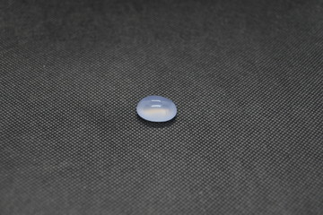 Natural Chalcedony in a shape of cobochon on black fabric background.
