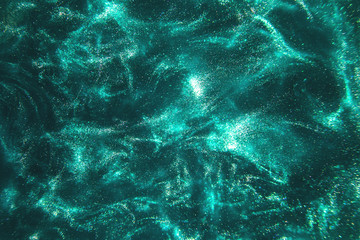 Abstract elegant, detailed mint glitter particles flow with shallow depth of field underwater. Holiday magic shimmering luxury background. Festive sparkles and lights. de-focused.