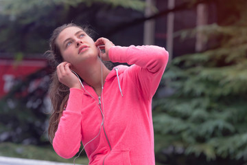 Naklejka premium Healthy young female sporty woman prepairing for running in morning on street, using phone before running. Runner training outdoors in morning.