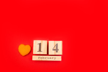 Wooden calendar on a red background. Valentine's Day February 14