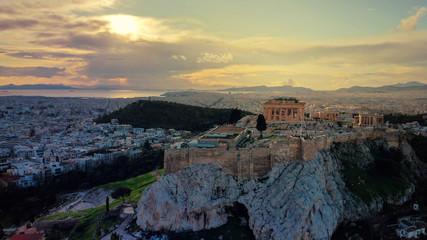 Fototapeta na wymiar Aerial drone panoramic photo of beautiful sunset with golden colours and clouds over iconic Acropolis hill and Masterpice of Western ancient civilisation - the Parthenon, Athens, Attica, Greece