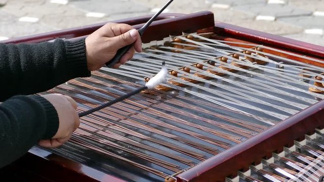 Street artist fiddler plays at the cymbal-on