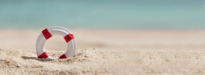 Lifebuoy On Sand At Beach - obrazy, fototapety, plakaty
