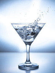 one glass of water with splash from falling ice cube, white background, isolated object
