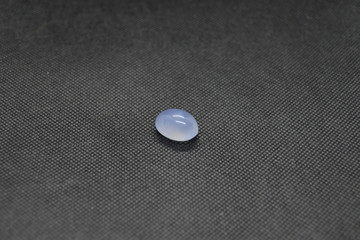 Natural Chalcedony in a shape of cobochon on black fabric background.
