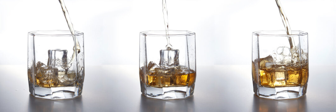 set of Isolated shots of whiskey with splash on white background. whiskey poured into a glass with ice