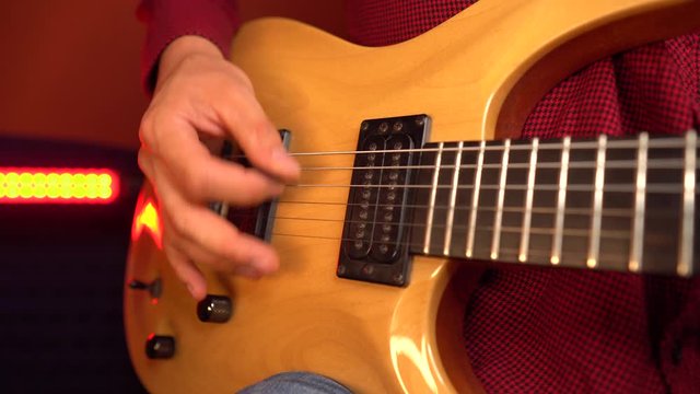Close up of man hand playing the funky rhythm on electric guitar