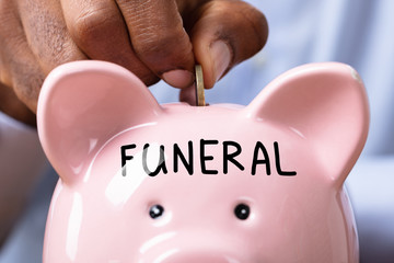 Man Inserting Coin In Piggybank