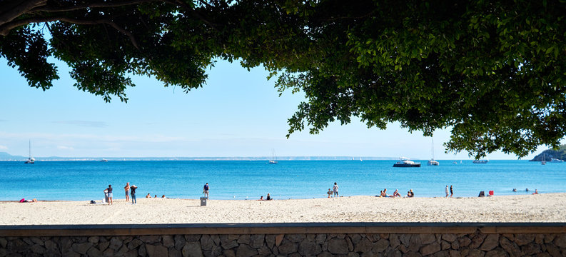 People tourists enjoy warm weather on Palma Nova sandy beach beautiful place, bright colors. Spanish Balearic island of Mallorca, municipality of Calvia. Travel and tourism, vacation concept