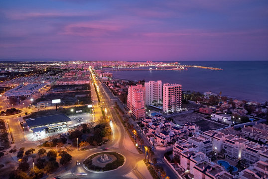 Aerial photo top view of Torrevieja spanish resort city during sunset purple violet colour cloudy sky, picturesque sundown, Province of Alicante, Costa Blanca, Spain, Europe
