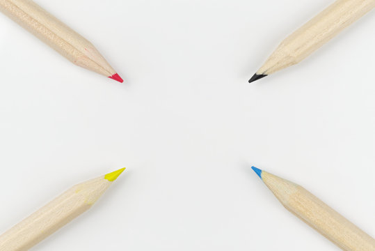 Four colored pencils on a white background arranged as a target