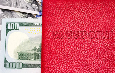 Close up of a red color passport cover with US dollars banknote background. Concept people travel.