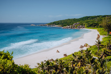 Grand Anse beach at La Digue island in Seychelles from view point above. White sandy beach with blue ocean lagoon and granite boulders