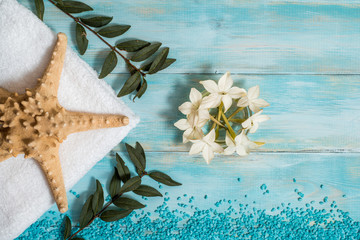 Spa and wellness setting with flowers, and white towel on old wooden background. Blue dayspa nature set. copyspace. Vacation concept. flat lay. top view.