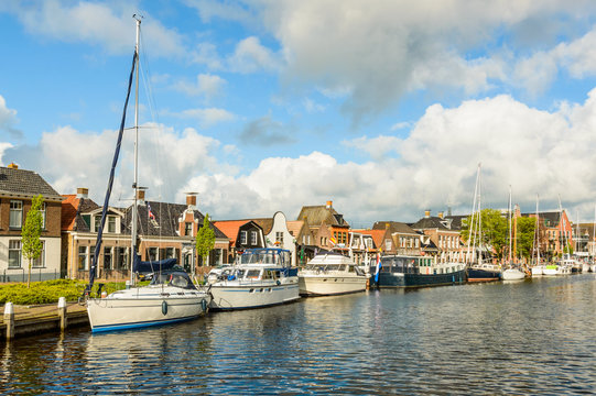 Dutch canal with moored boats on the shore, city of Lemmer.