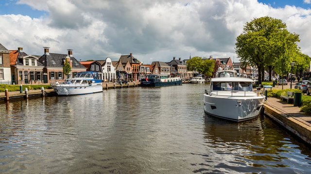 Dutch canal with moored boats on the shore, city of Lemmer.