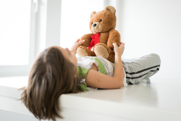Child at home with Teddy bear
