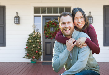 Fototapeta premium Chinese and Caucasian Young Adult Couple On Christmas Decorated Front Porch of House