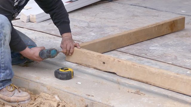 Carpenter screws together a wooden frame - medium shot and close-up 4K