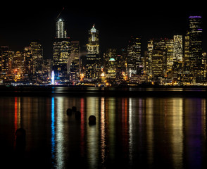 Night Seattle City Skyline eith Ferris Wheel overlooking Puget Sound Waters with Buoys in Foreground