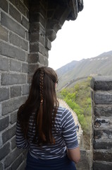 Fototapeta premium Ragazza che guarda l'orizzonte sulla muraglia cinese