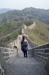 Fototapeta na wymiar Ragazza che guarda l'orizzonte sulla muraglia cinese