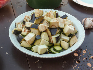 Close-up view of pieces of raw zucchini and eggplant in a salad bowl