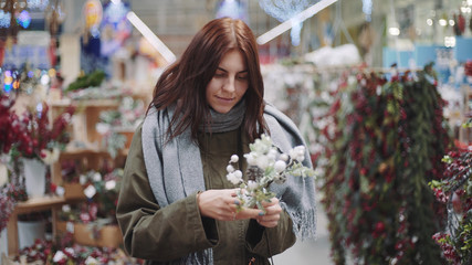 A young beautiful woman walks around the store and selects Christmas decorations and decorations to celebrate the New Year. New year shopping 