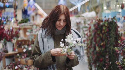 A young beautiful woman walks around the store and selects Christmas decorations and decorations to celebrate the New Year. New year shopping 