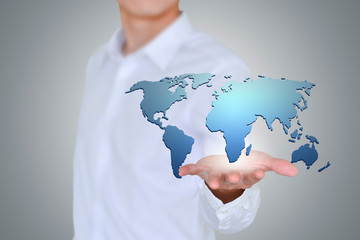 A business man holds a world map.