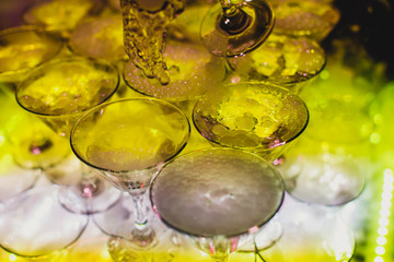 Beautiful tower line of different colored alcohol cocktails wit on a party event, tequila, martini, vodka, and others on decorated catering banquet table