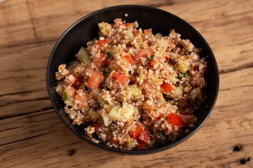 Traditional Arabic Salad Tabbouleh with couscous, vegetables and greens