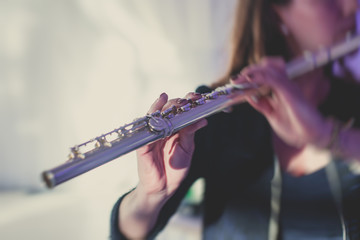 Concert view of a flutist flute player with musical jazz band and audience in the background
