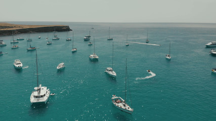 Aerial View of many yachts in a bay on Formentera island. Cala Saona bay drone footage. Yachting in...