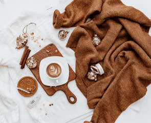 Flat lay with hot coffee on wooden boar with warm sweater, woman accessory Cozy winter atmosphere. Christmas concept. Flat lay