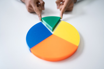 Fototapeta premium Businessperson Placing A Last Piece Into Pie Chart