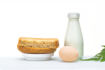 A nutritious breakfast of bread and eggs with milk, garnished with a green leaf.