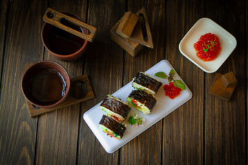 Fototapeta na wymiar hot roll set sashimi japanese food on wooden black background top view