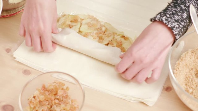 Woman's hands rolling phyllo dough to make Viennese strudel