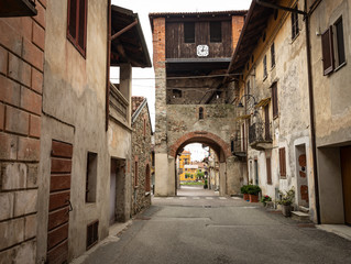 a street and the bell tower in Piverone town, Turin, region Piemonte, Italy