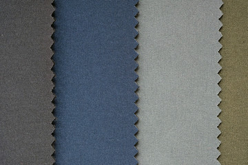 Samples of fabrics in pastel shades. Gray and blue piece of dense fabric close-up.