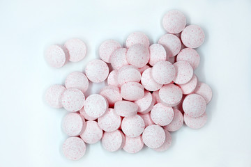 Pink pills on a gray background top view. Vitamins B12 are useful food supplements.