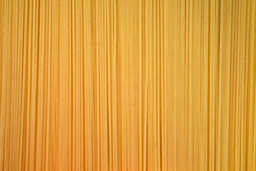 Thin spaghetti closeup top view. Uncooked spaghetti background, flour products.