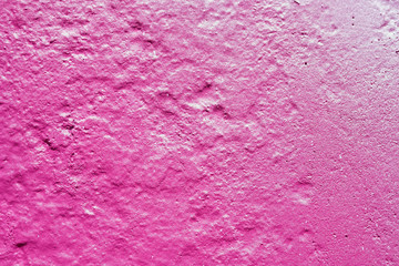 texture of a painted wall. cement plate pink color background. wall with bumps and small pits.