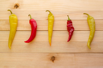 Pods of red and green pepper on a wooden background. Spicy red and green pepper view from above.