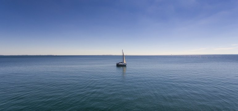 Wide Shot Of A Sailing Boat In The Middle Of The Peaceful Ocean