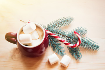 Red cup with marshmallows mashmeu and Christmas hook stick. The background for the New Year's card.